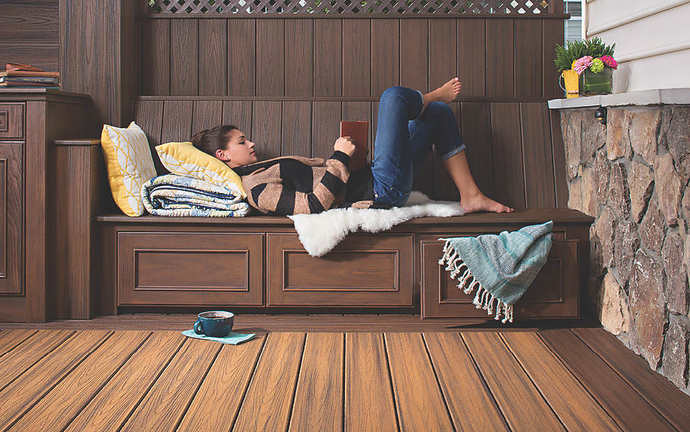 Woman reading book on wood built in bench